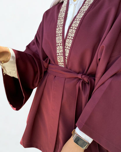 Maroon robe with gold embroidery on a white background