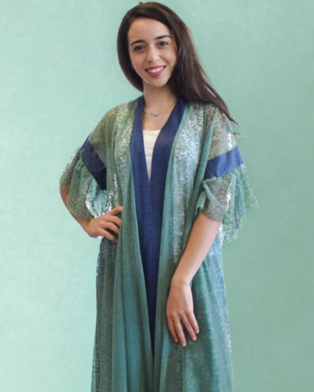 Woman wearing a green and blue patterned kimono against a light green background