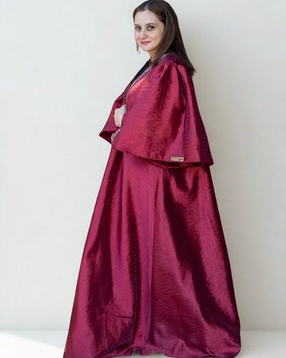 Woman wearing a maroon traditional outfit with a plain background