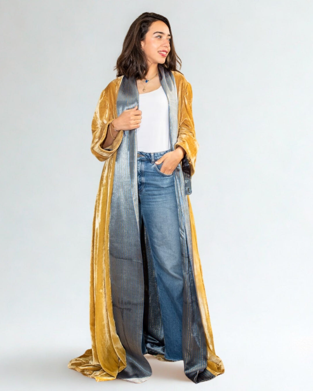 Woman wearing a long, gradient scarf with gold, blue, and gray colors on a white background.