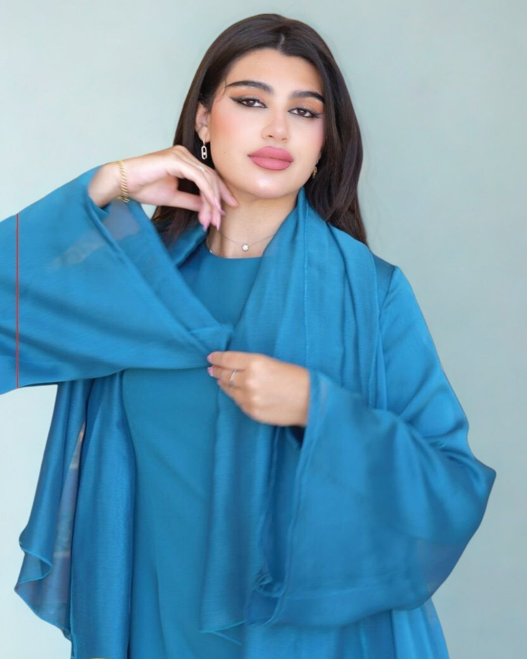 Woman wearing a blue outfit against a plain background