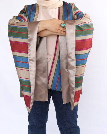 Colorful striped shawl draped over a person on a white background