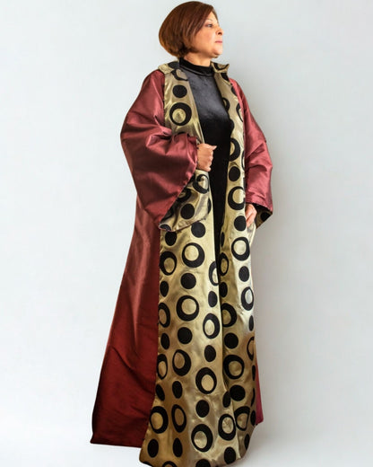 Woman wearing a long, patterned dress with a white background