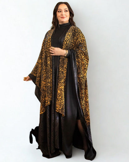 Woman wearing a black dress with a leopard print shawl on a white background