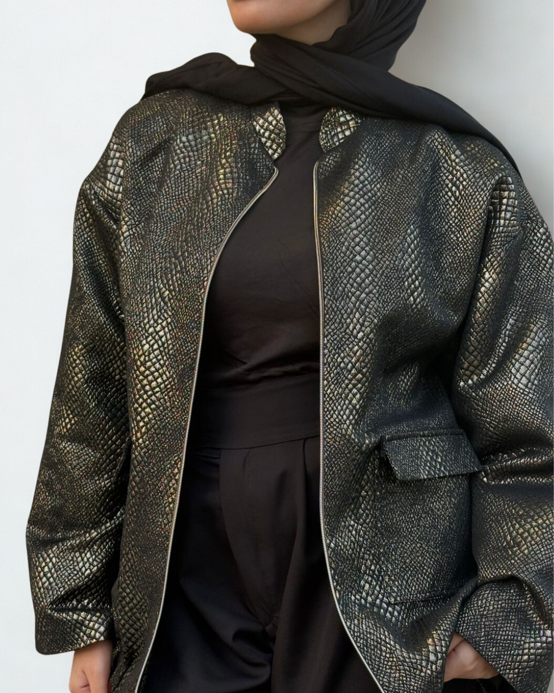Person wearing a patterned jacket over a plain background
