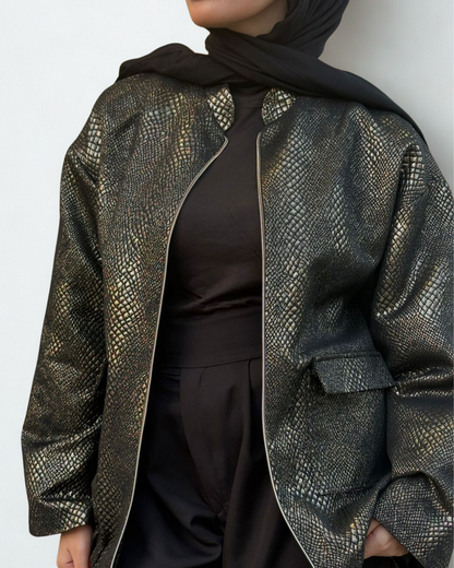 Person wearing a patterned jacket over a plain background