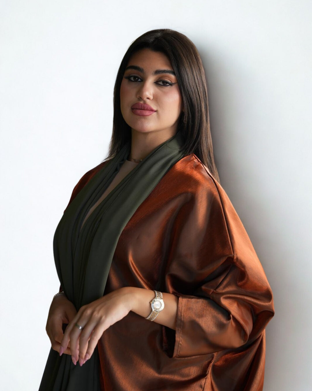 Woman wearing a brown and green scarf against a white background