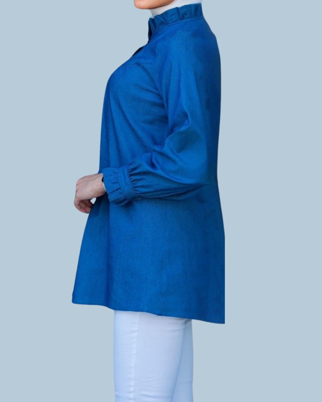 Blue long-sleeve top worn by a person on a light gray background