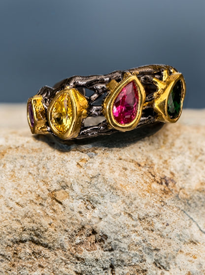 Ring with colorful gemstones on a stone surface