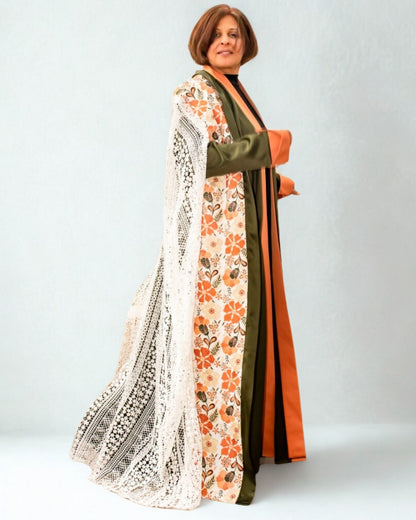 Woman wearing a long, patterned dress with floral design on a plain background