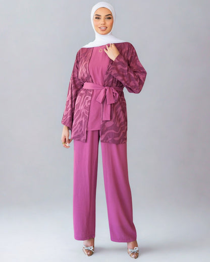 Woman wearing a maroon outfit with a matching hijab on a white background