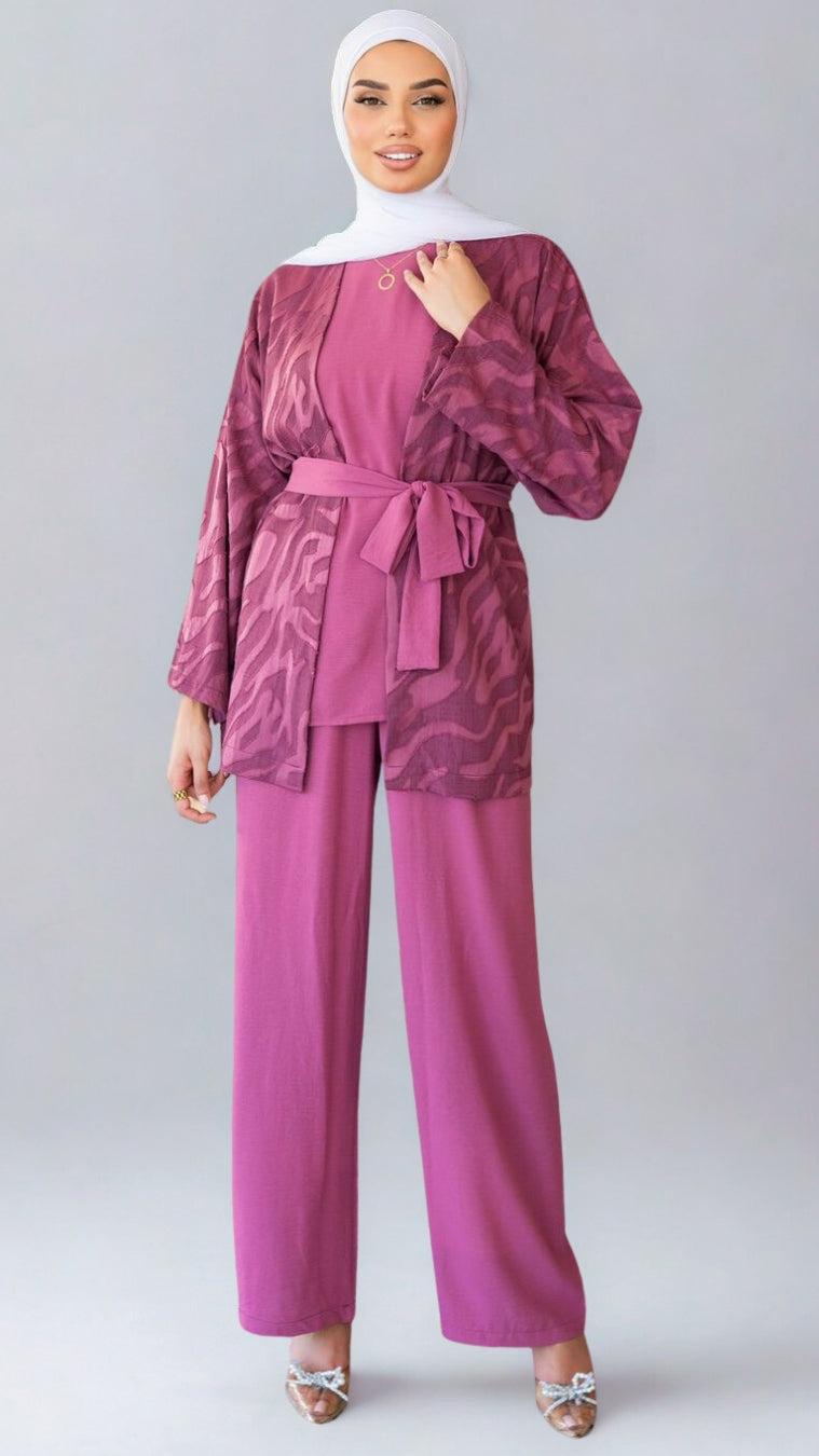 Woman wearing a maroon outfit with a matching hijab on a white background