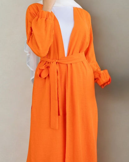 Orange dress with a belt on a mannequin against a beige background