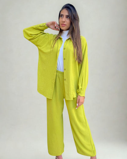 Woman wearing a bright yellow outfit against a plain background
