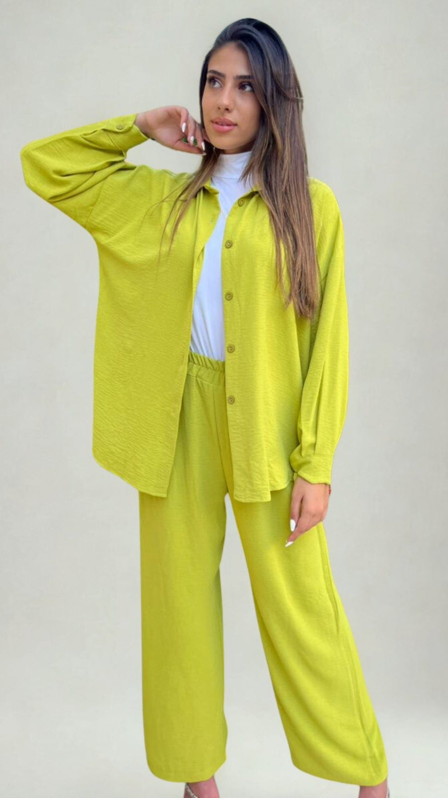 Woman wearing a bright yellow outfit against a plain background