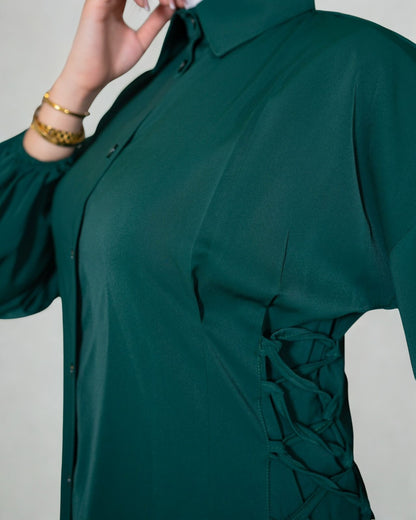 Green shirt with lace-up front detail on a plain background