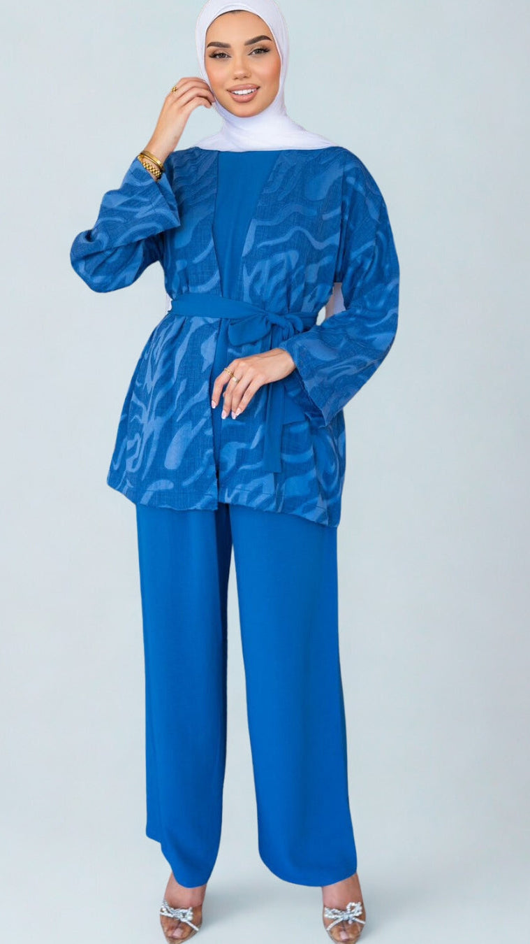 Woman wearing a blue patterned top and matching pants on a white background
