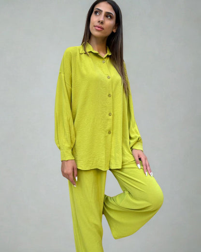 Woman wearing a bright green outfit against a plain background