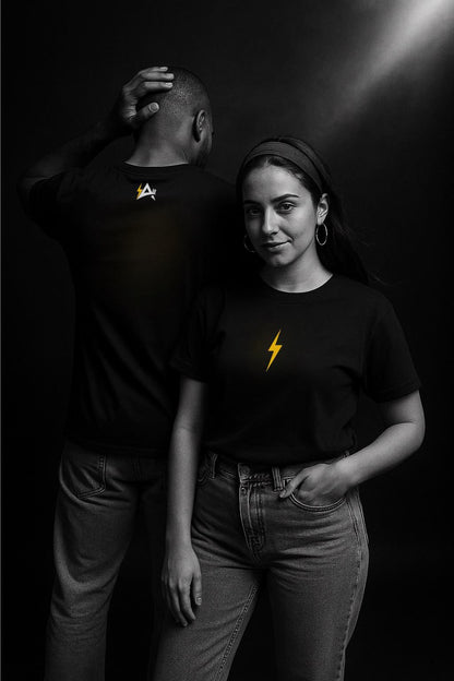 Two people wearing black t-shirts with yellow designs against a dark background
