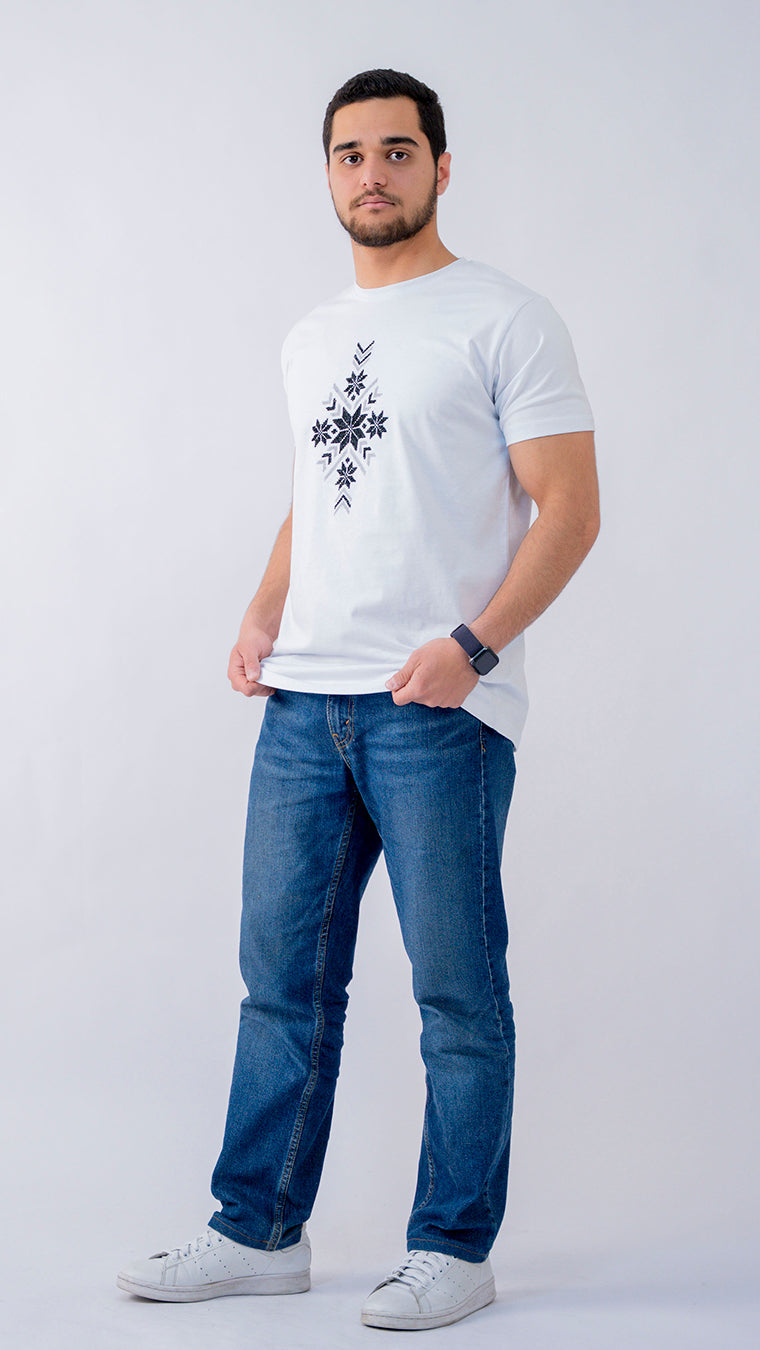 Man wearing a white t-shirt with a black design and blue jeans on a white background