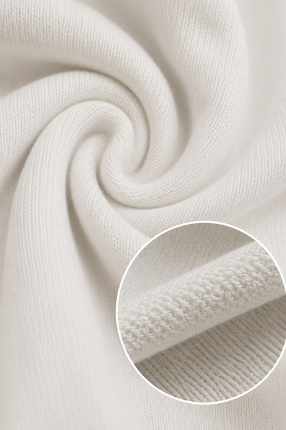 Close-up of a soft off-white knit fabric swirled in a spiral, with a circular inset showing a detailed view of the ribbed knit texture.