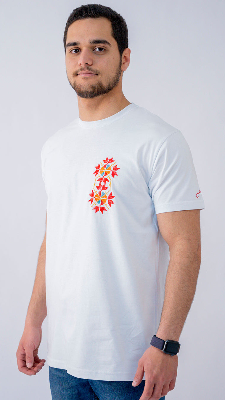 Man wearing a white t-shirt with a colorful design on a plain background