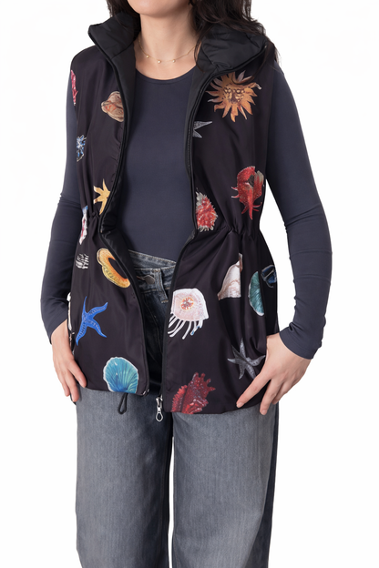 Person wearing a black hooded jacket with colorful sea creature patterns on a white background