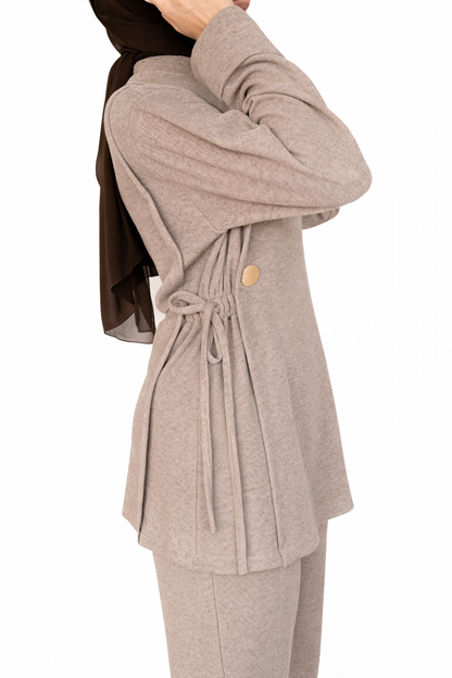 Beige cardigan with a tie front and button detail on a white background