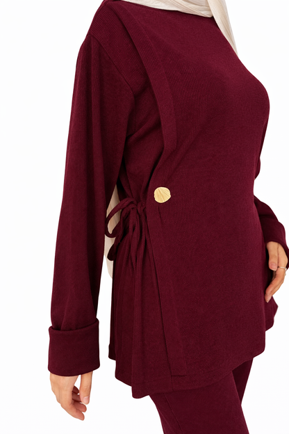 Maroon outfit with a gold button on a white background