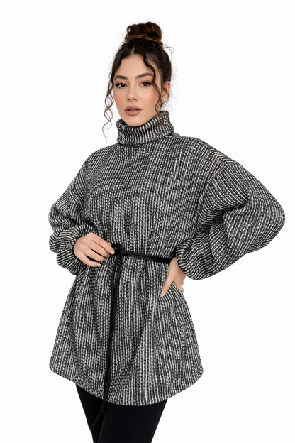 Woman wearing a black and white patterned dress with balloon sleeves on a white background