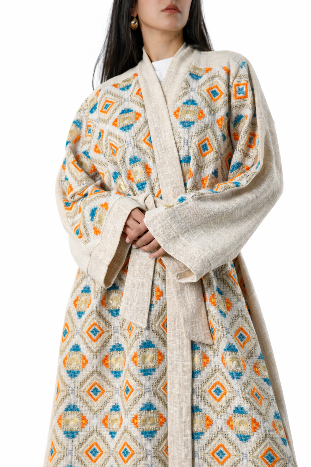 Woman wearing a patterned coat with geometric designs on a white background