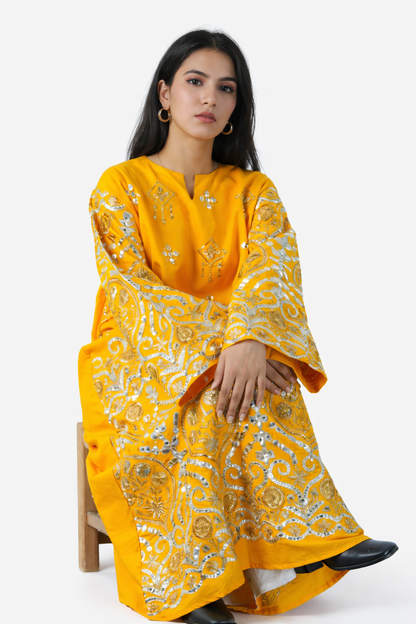 Woman wearing a yellow and white patterned kurta with pants on a white background