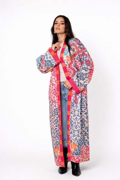 Woman wearing a colorful patterned coat on a white background