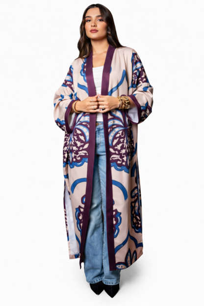 Woman wearing a long, patterned cardigan over a white top and jeans on a white background