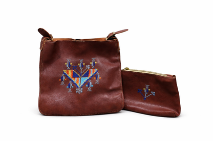 Brown leather handbag with embroidered design and matching pouch on a white background