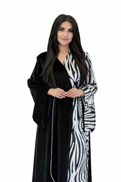 Woman wearing a black and white zebra-patterned abaya on a white background
