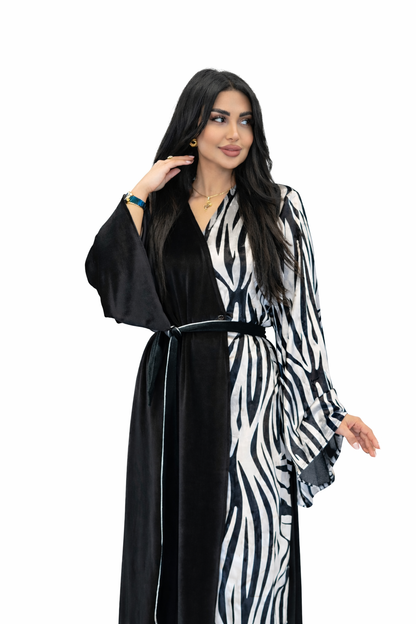 Woman wearing a black and white zebra print dress with a plain background
