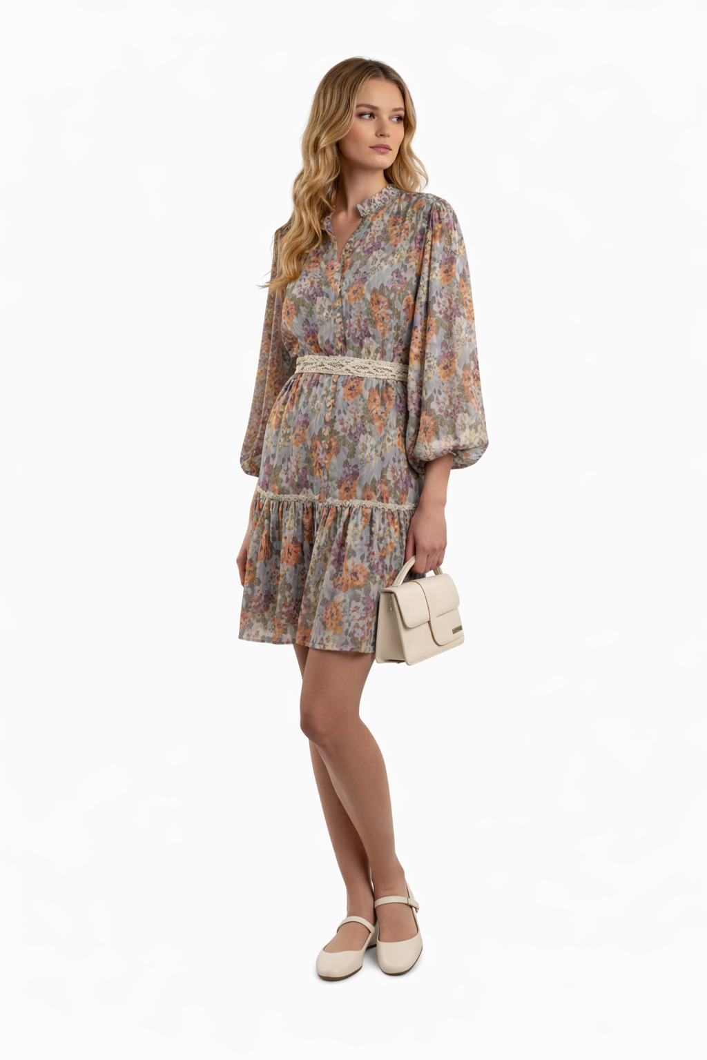 Woman wearing a floral dress holding a beige handbag on a white background