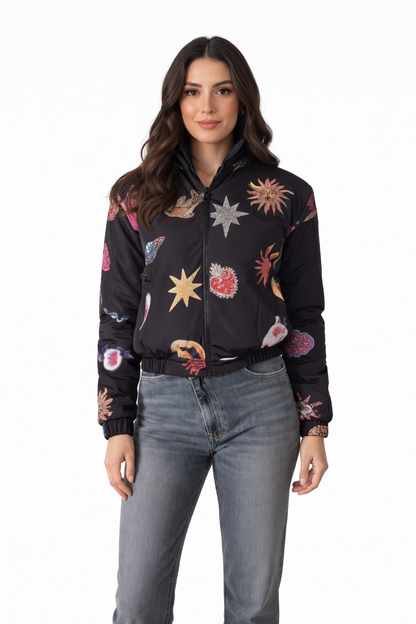 Woman wearing a black bomber jacket with colorful abstract patterns on a white background