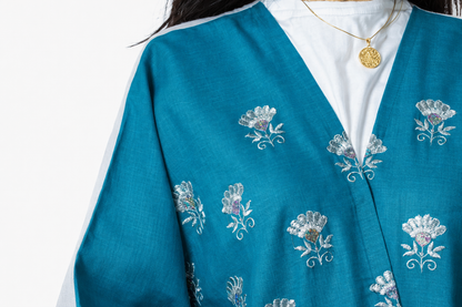 Teal cardigan with floral embroidery on a white background