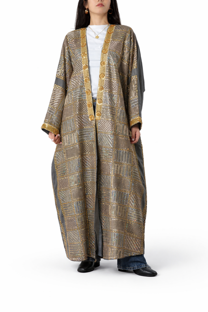 Long, patterned dress with gold accents worn by a person on a white background