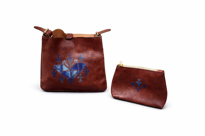 Brown leather bags with blue embroidery on a white background