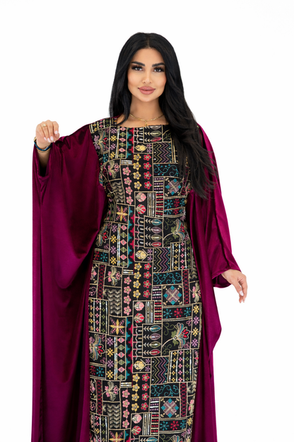 Woman wearing a patterned dress with a burgundy cloak on a white background