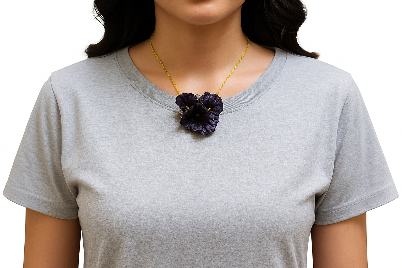 Person wearing a gray t-shirt with a necklace featuring a dark purple flower pendant on a white background