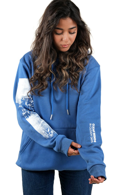 Woman wearing a blue hoodie with white arm designs and text on a white background