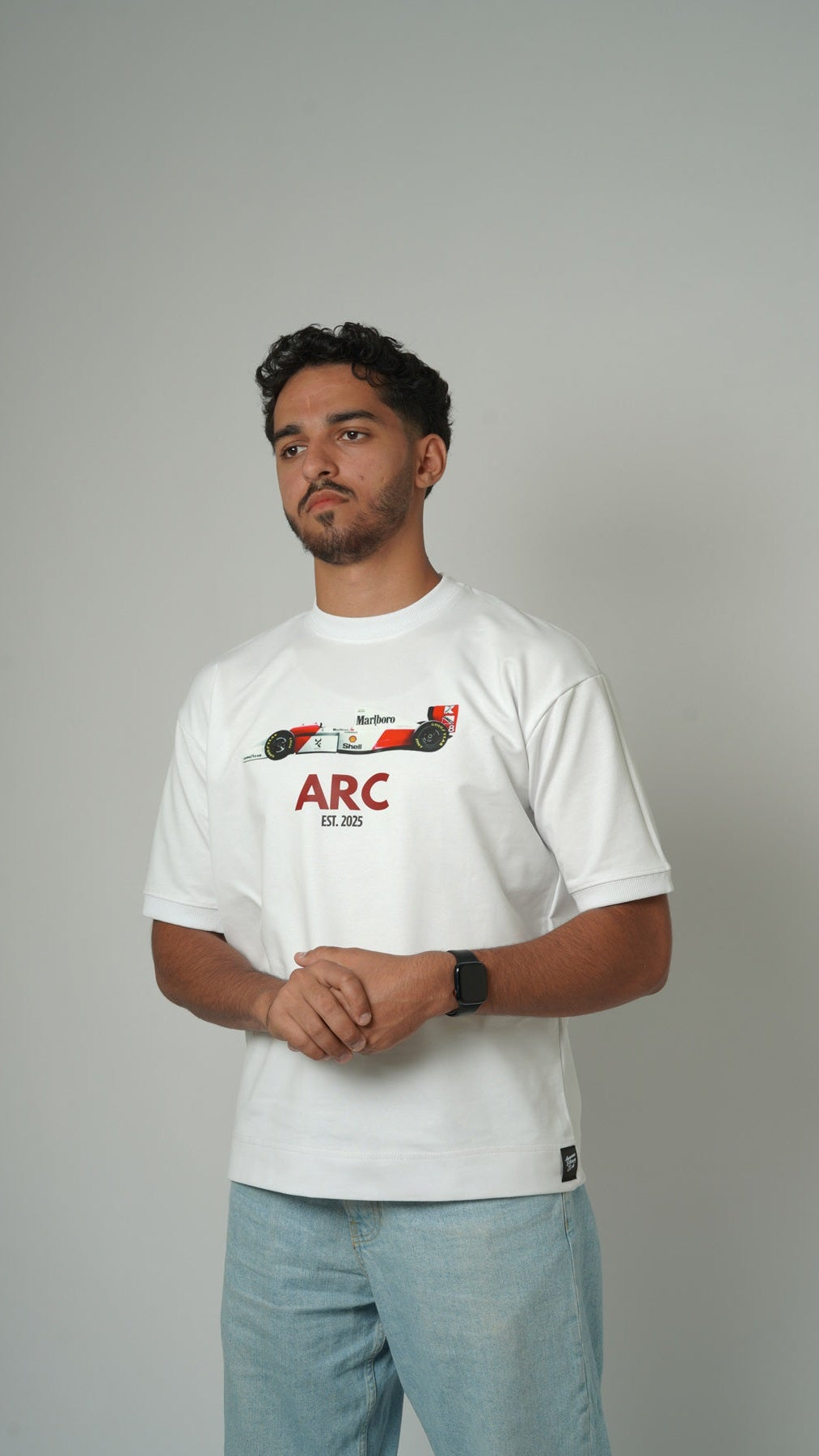Man wearing a white t-shirt with a graphic design on a gray background