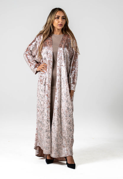 Woman wearing a long floral dress against a white background