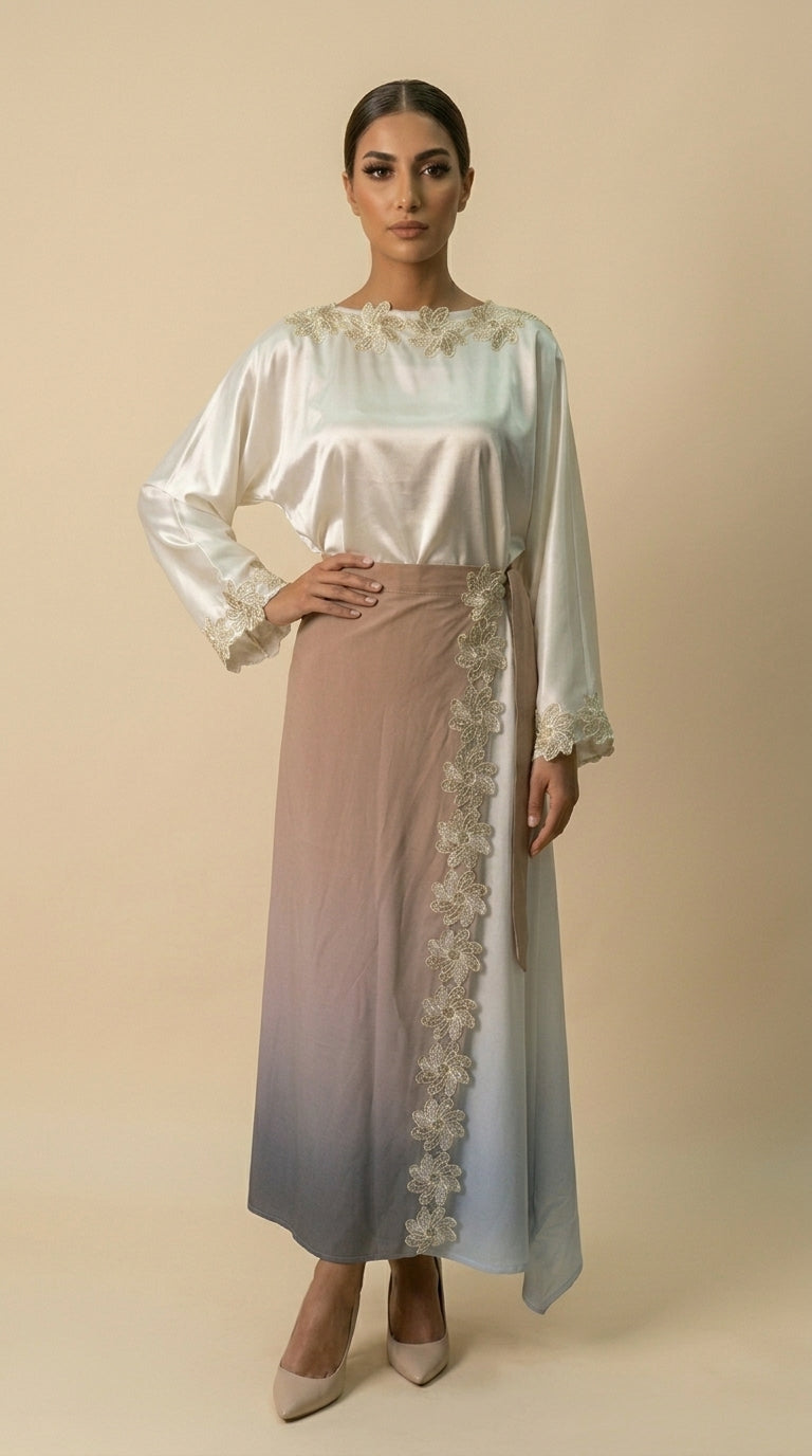 Woman wearing a long, light-colored dress with lace details on a beige background