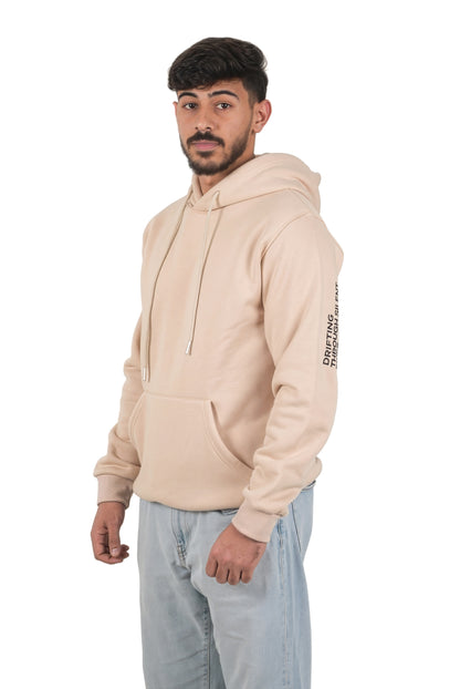 Man wearing a beige hoodie with text on sleeves against a white background