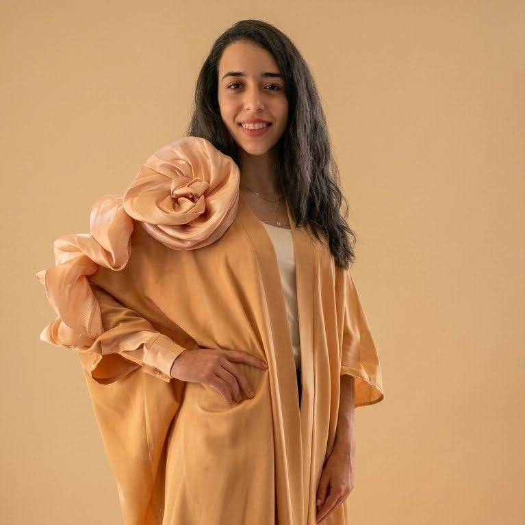 Woman wearing a peach-colored kimono-style garment against a beige background